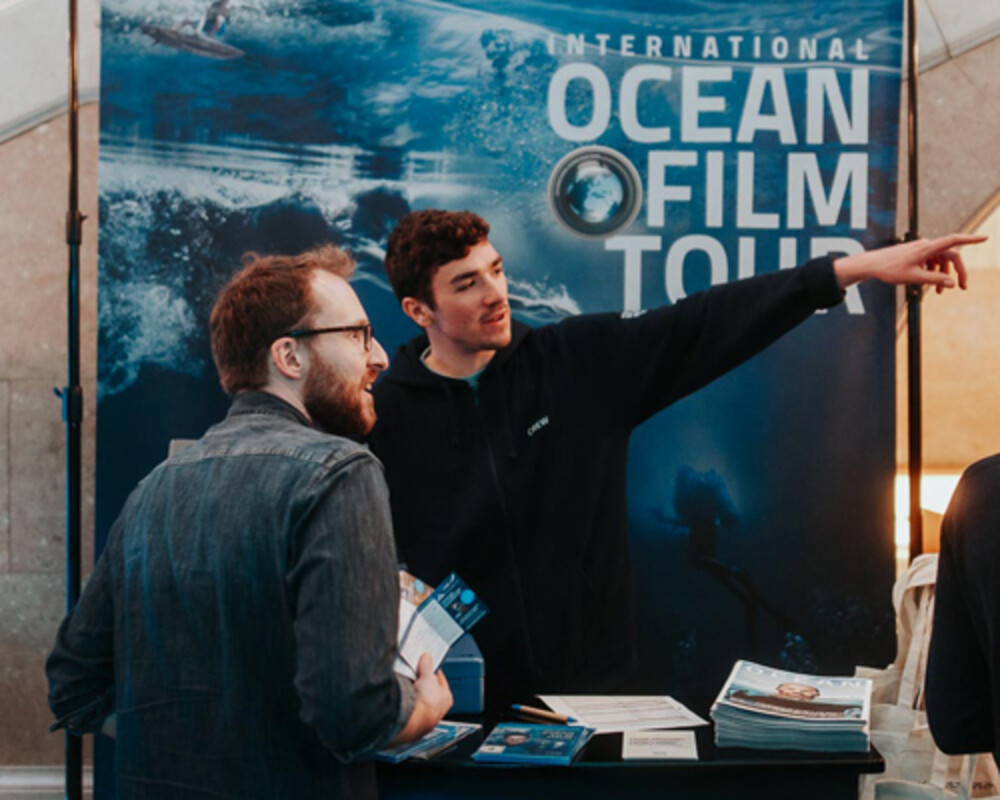 Stand de l&rsquo;International Ocean Film Tour avec des employ&eacute;s informant les visiteurs et distribuant des brochures.