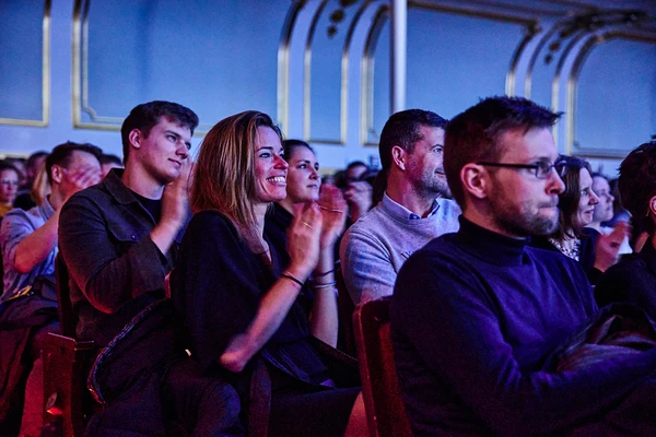 Public applaudissant lors d’un événement dans une salle élégante