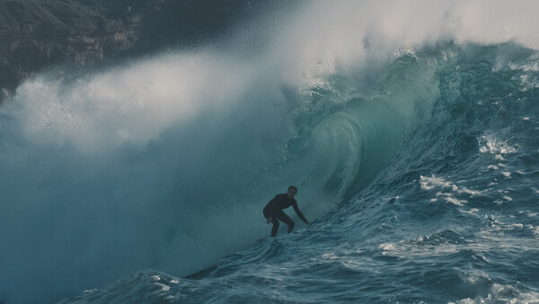 Eine Person surft durch eine große Welle
