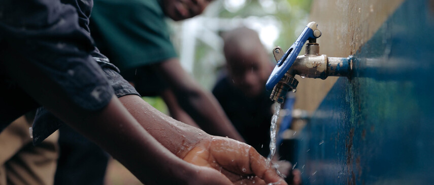 Eine Gruppe mit bunten bemalten M&uuml;lltonnen und Viva Con Agua Schildern und Flaggen